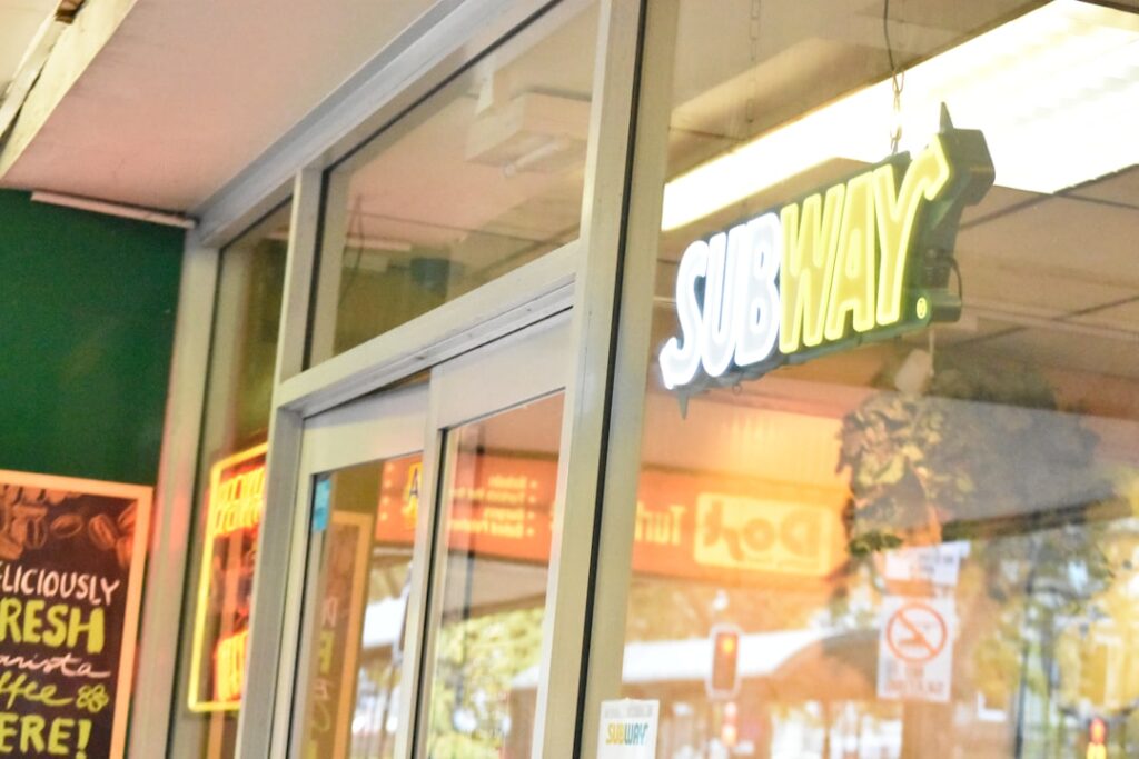 Subway Closes 729 More Stores Amid Strategic Restructuring Subway restaurant exterior with illuminated sign