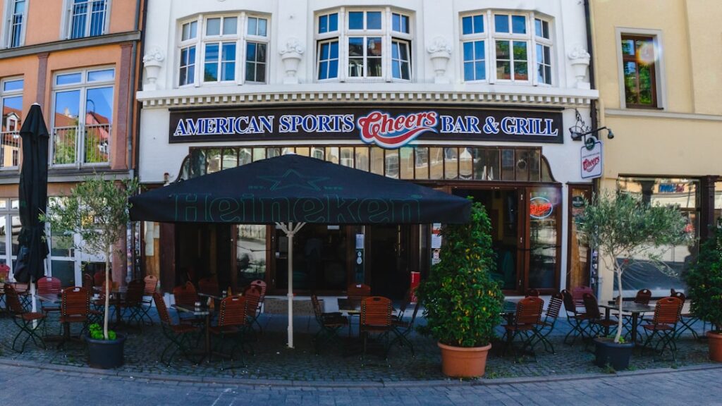 Victory Bar & Grill Sold in West Berlin Transaction an outdoor restaurant with tables and chairs in front of a building