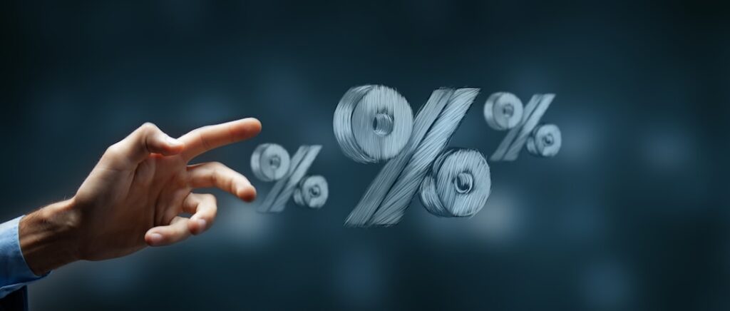 What Determines Your Commercial Loan Interest Rate Hand reaching towards floating percentage symbols.